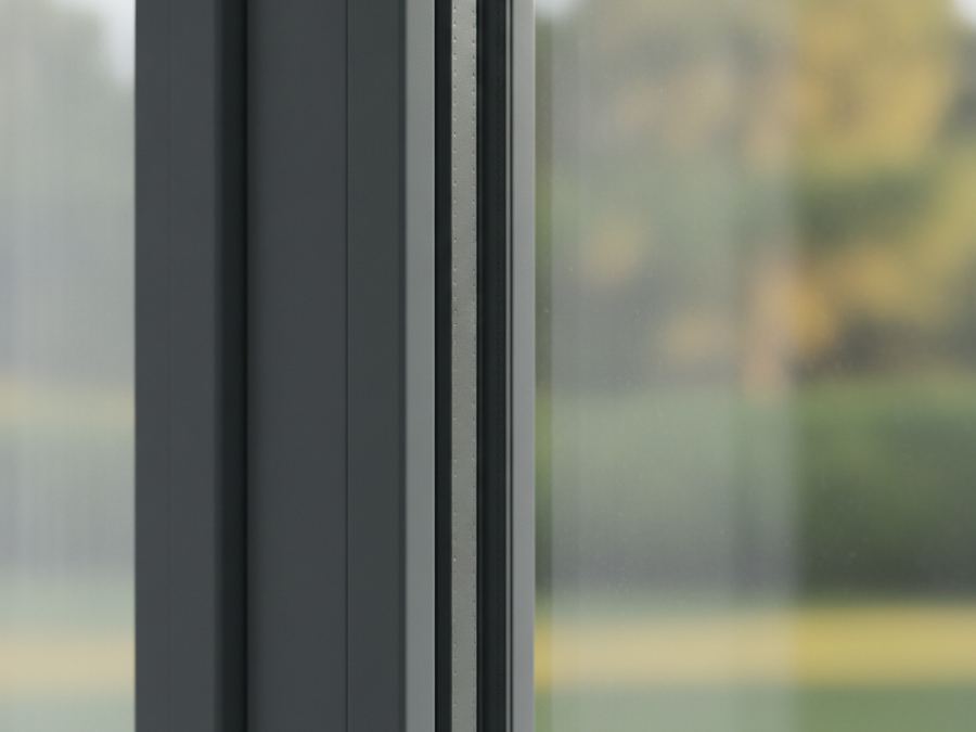 Nahaufnahme einer Aluminium-Fensterrahmen-Ecke mit Dichtung, verschwommenes Grün im Hintergrund